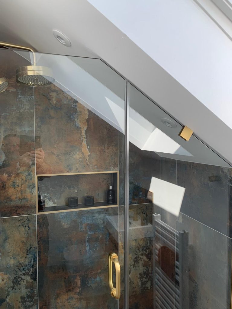 Minimalist brushed gold handle on frameless bespoke shower glass