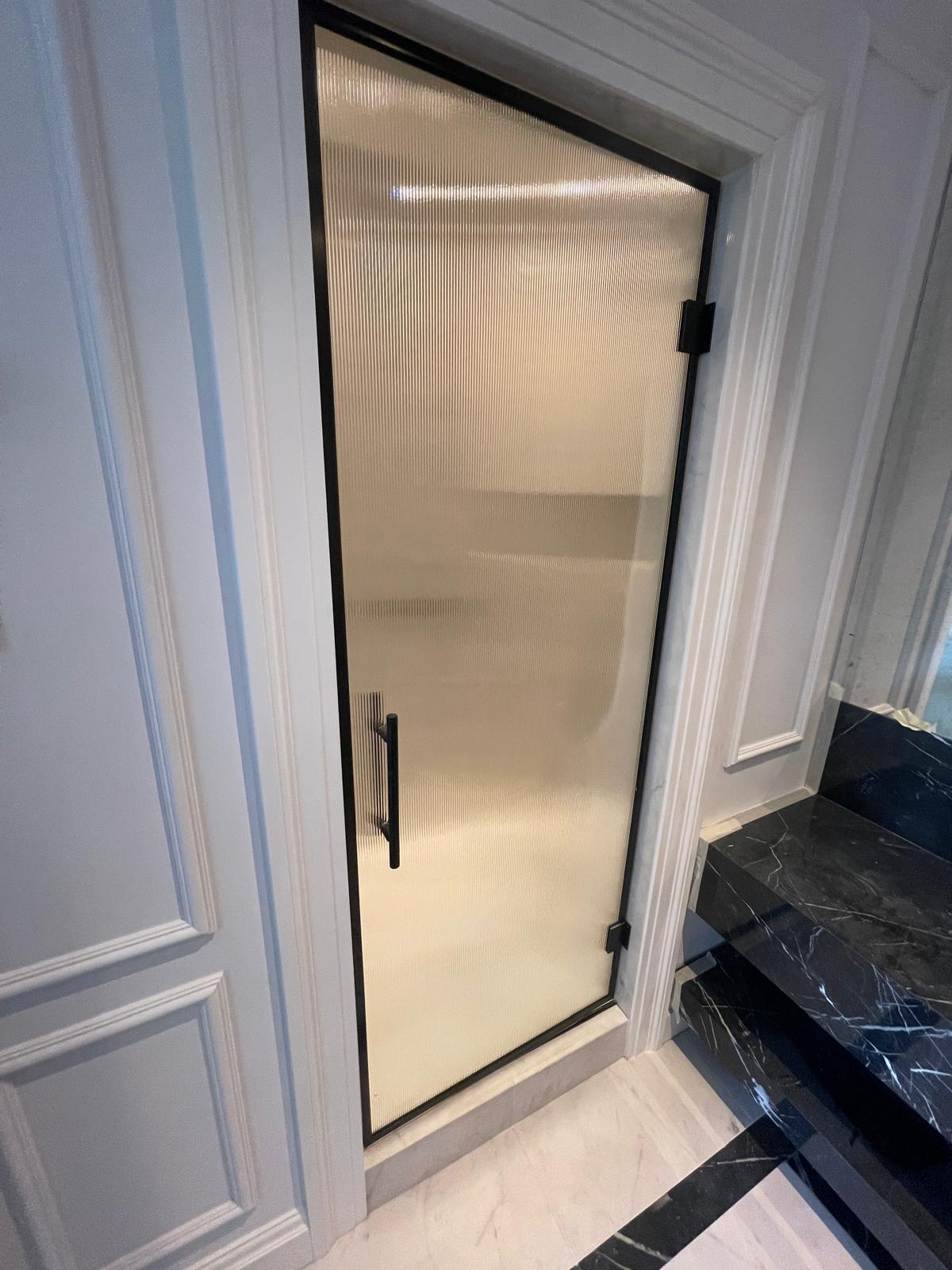 Visiosun® glass shower door in Cheshire framed with matte black U channel and handle