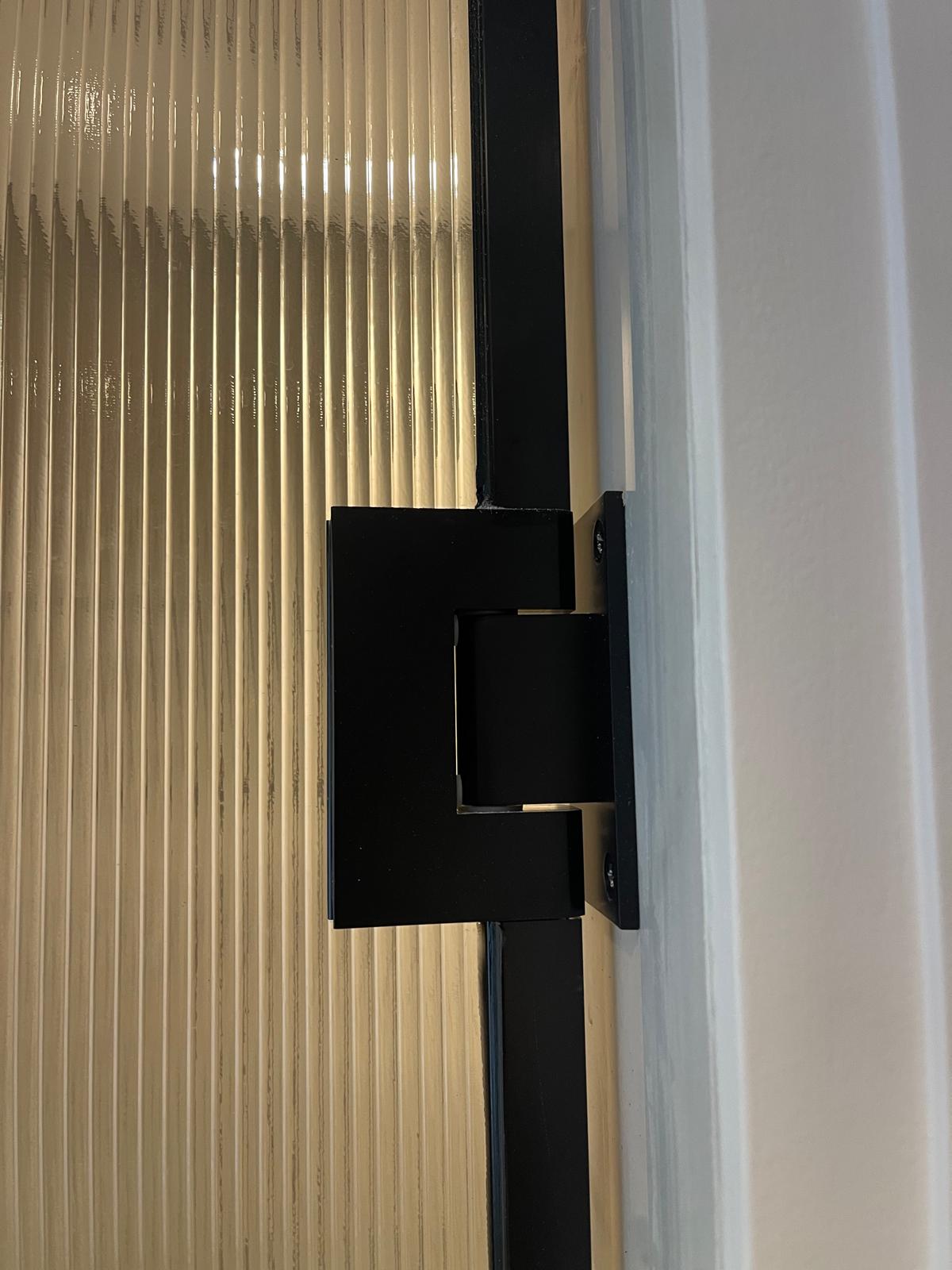 lose-up of Visiosun® glass shower door with matte black hinge and U channel in Cheshire