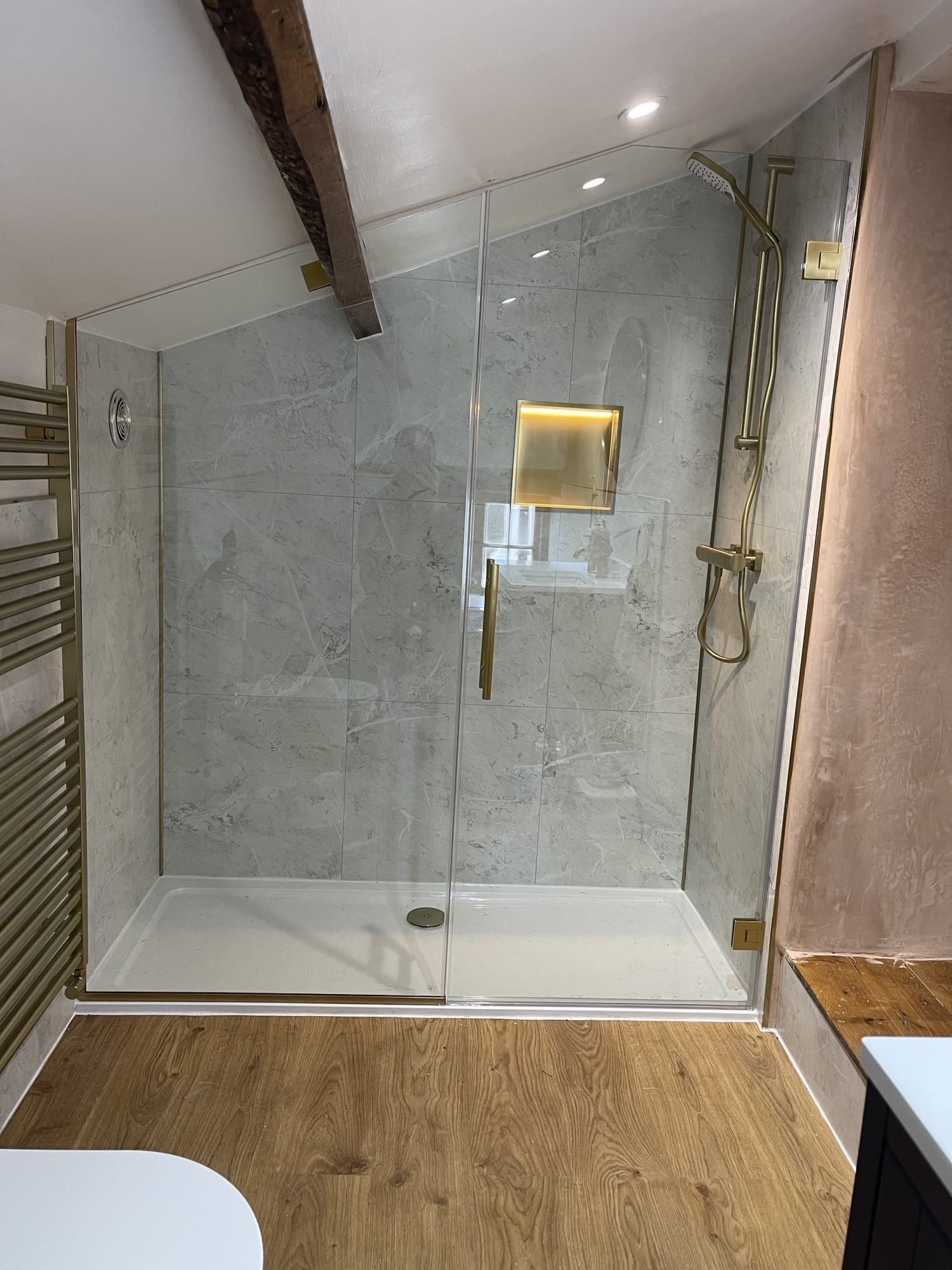 Bespoke shower enclosure installation in Denbigh with clear toughened glass and brushed brass hardware