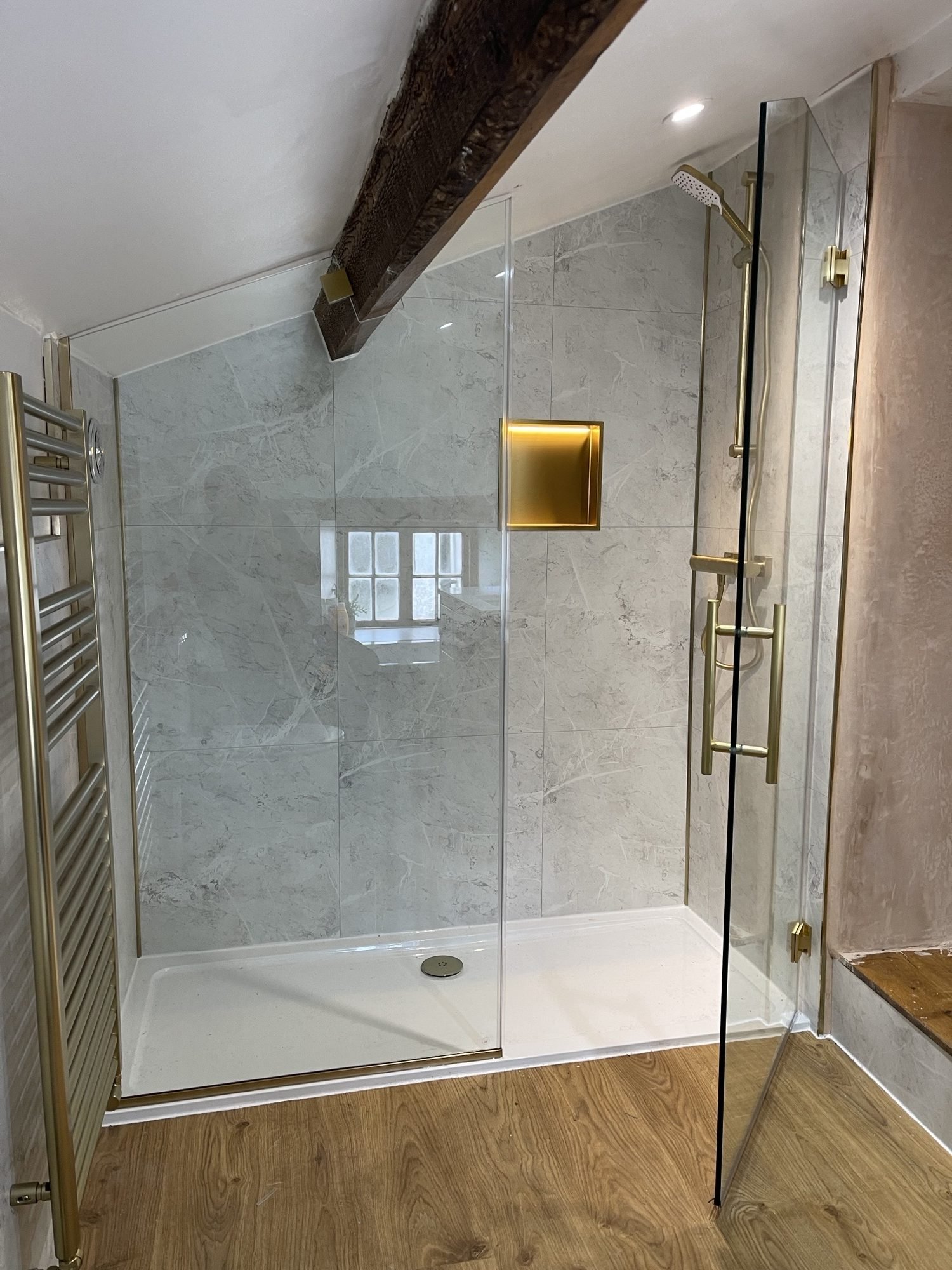 Bespoke shower enclosure installation in Denbigh with clear toughened glass and brushed brass hardware
